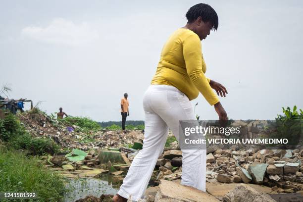 Godgift climbs through the rubble of her community, demolished by the government without plans for compensation relocation or dialogue, in Elechi,...