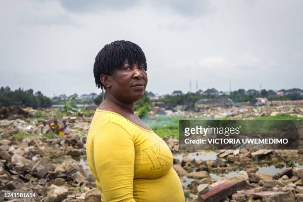 Godgift stands in the rubble of her former home in Elechi, Port Harcourt, Nigeria, on March 10, 2022. - Port Harcourt's communities are caught in a...