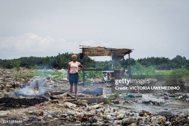 Woman stands in front of a poster of Governor Nyesom Ezenwo Wike, who justified the forced evictions by calling the informal settlements "safe havens...