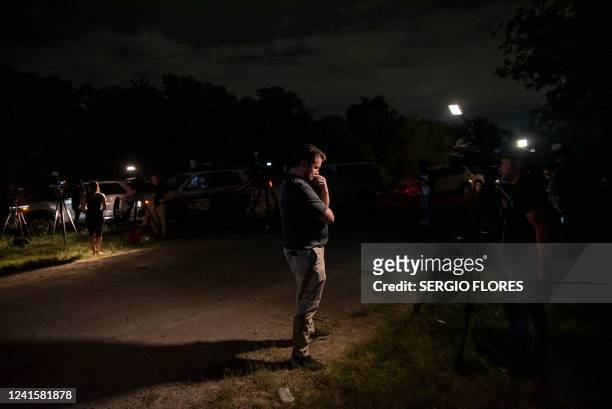 Reporter stands near the scene where a tractor-trailer was discovered with migrants inside outside San Antonio, Texas on June 27, 2022. At least 46...