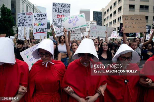 Abortion rights activists, dressed in an outfits from The Handmaid's Tale, lead protestors during a march in Denver, Colorado on June 27 four days...