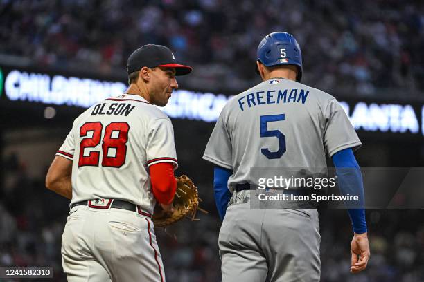 Atlanta Braves first baseman Matt Olson has a laugh with Los Angeles Dodgers first baseman Freddie Freeman after Freemans single in the sixth inning...