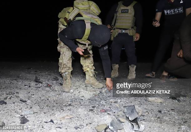 Fighters affiliated with the Hayat Tahrir al-Sham jihadist group in Syria inspect the site of a reported drone attack which targeted a motorcycle on...