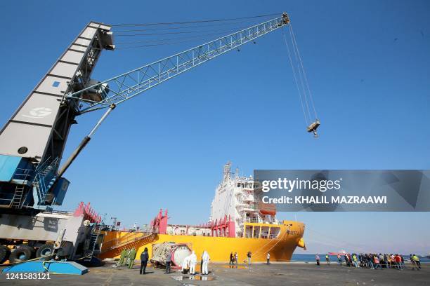 Forensics experts inspect the site of a toxic gas explosion by the Hong Kong-flagged vessel "Forest 6" in Jordan's Red Sea port of Aqaba on June 28,...