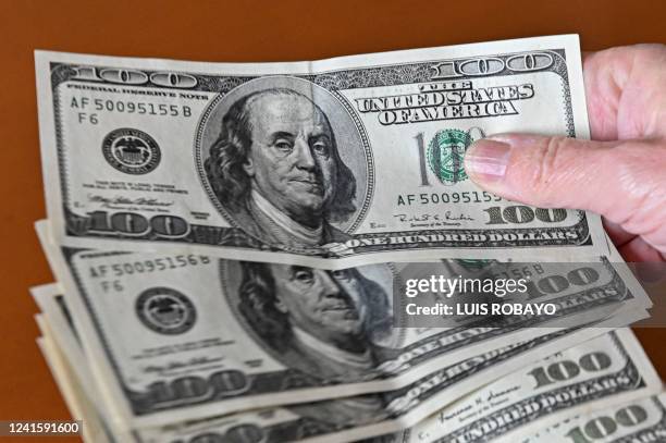 Dollar notes are photographed in Buenos Aires, on June 23, 2022. - Argentines do their accounts in dollars, traumatised by recurrent economic crises...