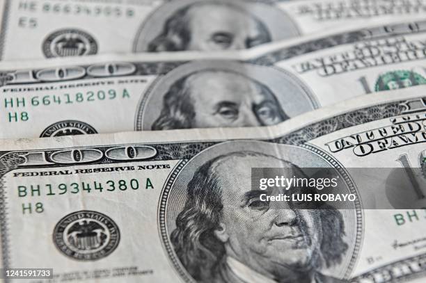 Dollar notes are photographed in Buenos Aires, on June 23, 2022. - Argentines do their accounts in dollars, traumatised by recurrent economic crises...