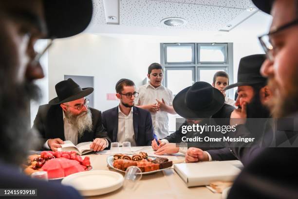 Groom Gabriel Grigoriev sits with Rabbi Avraham Wolf of Chabad Odessa and Rabbi Yehuda Teichtal as they prepare the "Ketubah" before a Jewish...