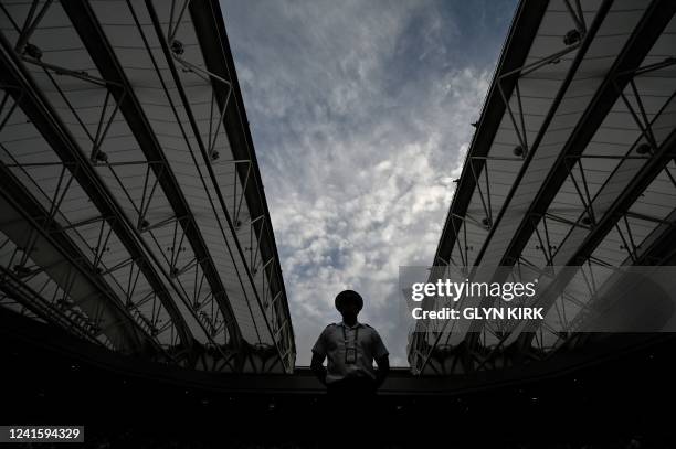 Service stuart stands guard as the roof of Centre court is closed during the women's singles tennis match between US player Serena Williams and...
