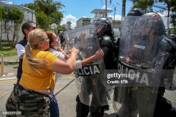 Relatives of inmates clash with riot police outside the prison in Tulua, Valle del Cauca Department, Colombia, on June 28 after several prisoners...