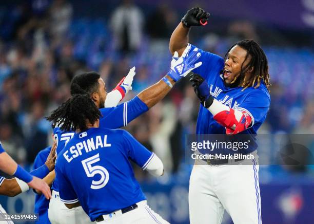 Vladimir Guerrero Jr. #27 of the Toronto Blue Jays celebrates his walk-off single in the ninth inning to defeat the Boston Red Sox 6-5 at the Rogers...