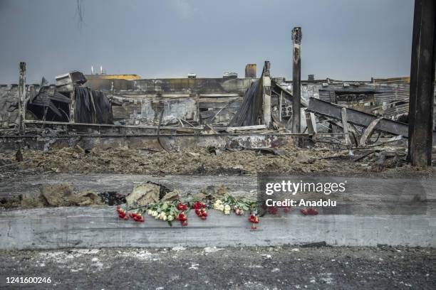 Buckets of flowers offered as memorial for the civilian victims are seen in a shopping mall targeted by a missile strike in Kremenchuk, Ukraine, June...