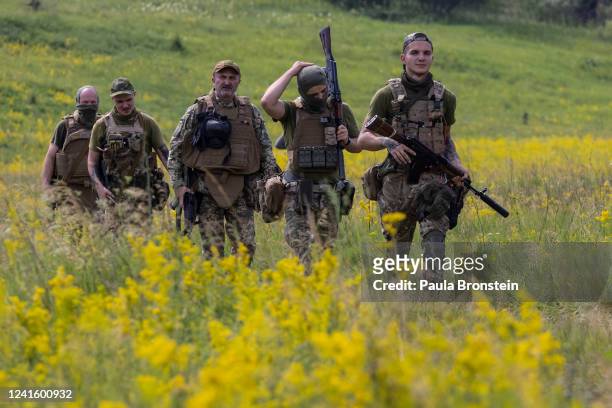 Azov Regiment soldiers walk through a field for tactical training on June 28, 2022 in the Kharkiv region, Ukraine.The Azov Regiment was founded as a...