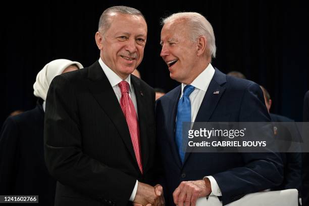 Turkey's President Recep Tayyip Erdogan and US President Joe Biden shake hands at the start of the first plenary session of the NATO summit at the...