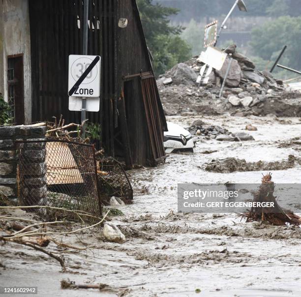 Debris and water stream downhill on a road among houses in Treffen, in the Villach-Land district of the Carinthia state, Austria, on June 29, 2022....