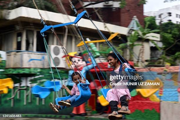 Children enjoy a ride at an amusement park in Dhaka on June 29, 2022.