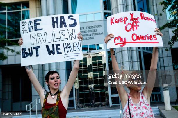Protestors hold placards expressing their opinion during a protest. Protestors gathered in front of a federal court house to protest the overturning...