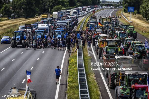 Farmers gather with their vehicles next to a Germany/Netherlands border sign during a protest on the A1 highway, near Rijssen, on June 29 against the...