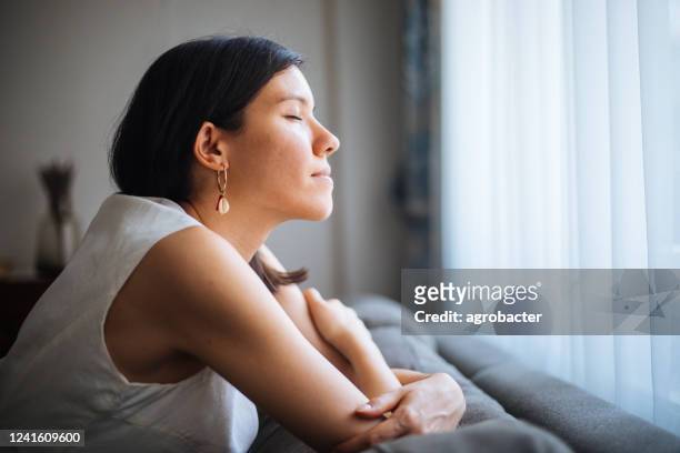 woman in front of the window - sitting eyes closed stock pictures, royalty-free photos & images