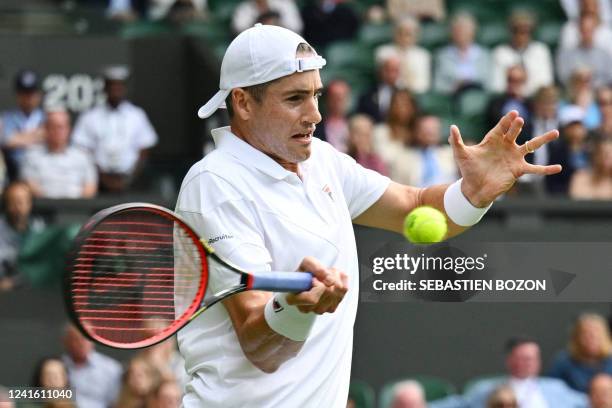 Player John Isner returns the ball to Britain's Andy Murray during their men's singles tennis match on the third day of the 2022 Wimbledon...