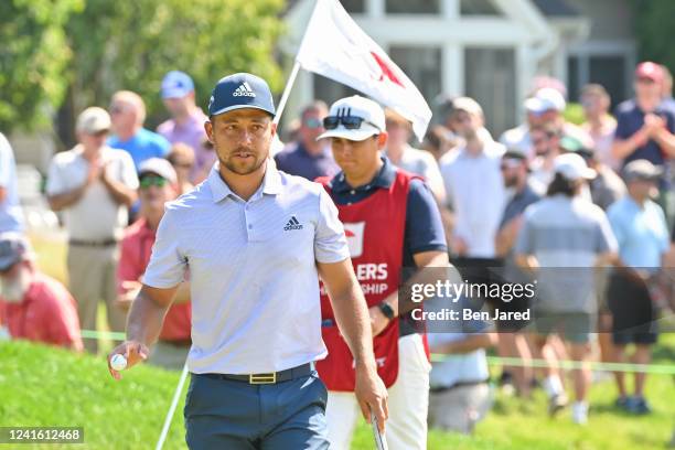 Xander Schauffele waves his ball while walking off the ninth green during the final round of the Travelers Championship at TPC River Highlands on...