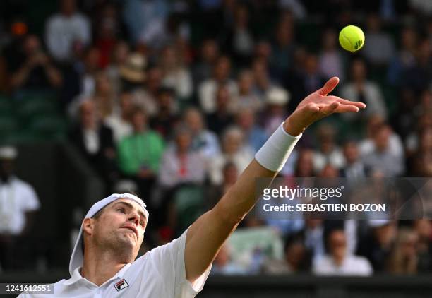 Player John Isner serves to Britain's Andy Murray during their men's singles tennis match on the third day of the 2022 Wimbledon Championships at The...