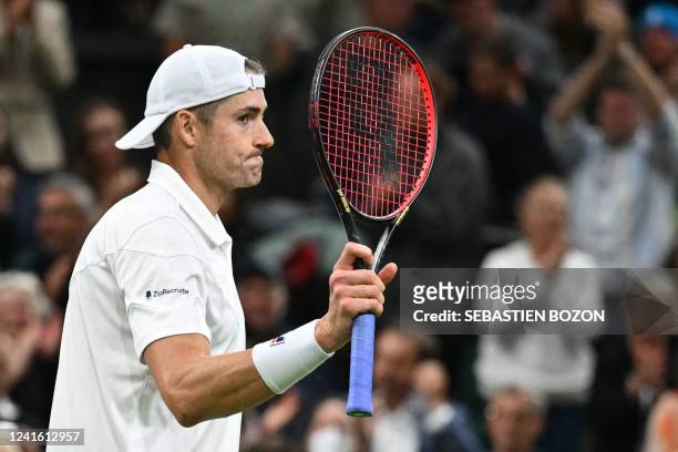Player John Isner celebrates beating Britain's Andy Murray during their men's singles tennis match on the third day of the 2022 Wimbledon...