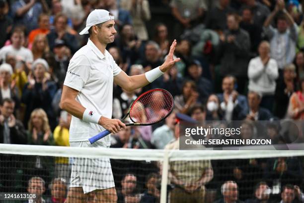 Player John Isner celebrates beating Britain's Andy Murray during their men's singles tennis match on the third day of the 2022 Wimbledon...