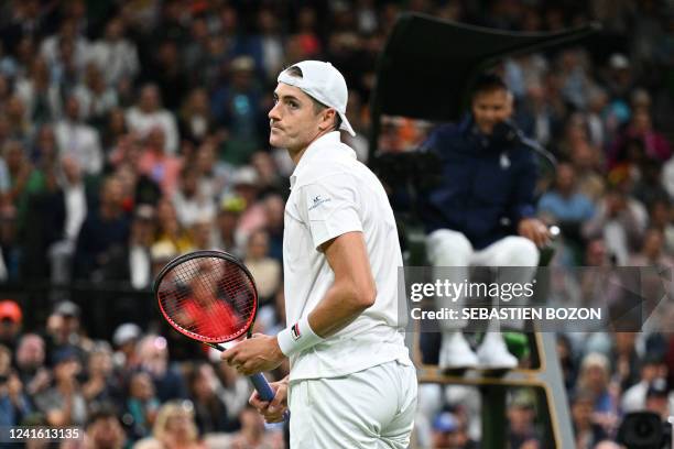 Player John Isner reacts after beating Britain's Andy Murray during their men's singles tennis match on the third day of the 2022 Wimbledon...