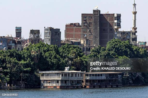 This picture taken on June 27, 2022 from the Cairo side of the Nile river shows houseboats moored along the Giza bank in the Agouza district, days...