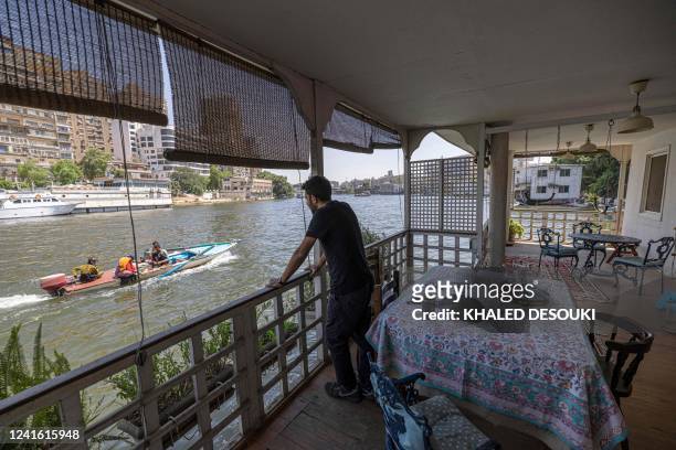 Egyptian-British national Omar Robert Hamilton stands at the balcony of his houseboat located in the Agouza district on the Giza bank of the Nile...