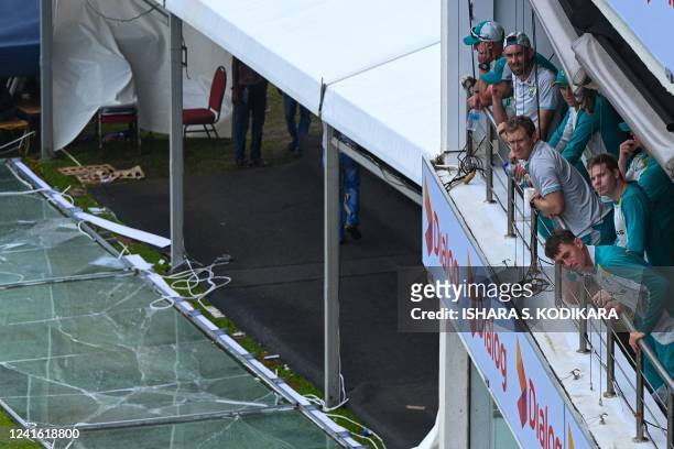 Australia's players look on from the pavilion as rain and wind stopped play during the second day of the first cricket Test match between Sri Lanka...