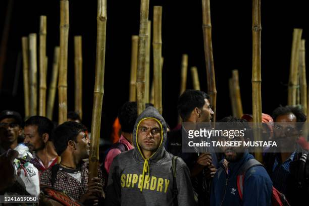 Porters wait as Hindu devotees gather in the early morning before starting their pilgrimage to the cave shrine of Amarnath from a base camp, near...