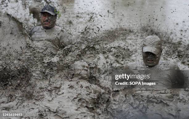 People play in mud water in a paddy field during the National paddy day celebration. Nepalese farmers celebrate National Paddy Day with various...