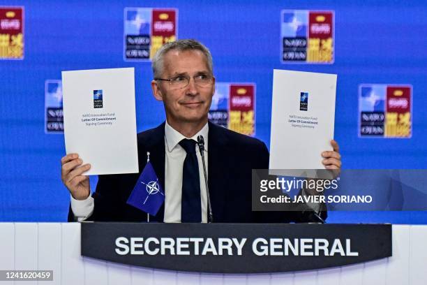 Secretary General Jens Stoltenberg presents the signed documents during the signing ceremony of the NATO Innovation Fund letter of commitment of the...