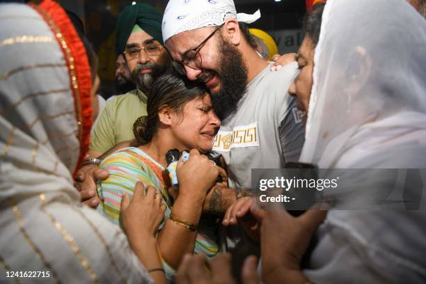 Members of the Afghan Sikh community react upon arriving from Afghanistan at the airport in New Delhi on June 30 following the June 18 attack by...