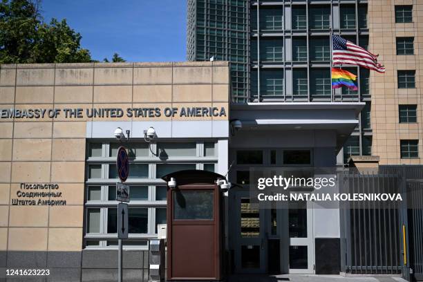 National and rainbow flags are pictured on the US embassy in Moscow on June 30, 2022. Moscow officials changed the official address of the US embassy...