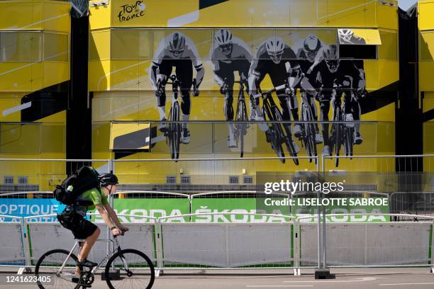 Man cycles past the finish area for the individual time trial competition in front of the Town Hall of Copenhagen, Denmark on June 30 a day ahead of...