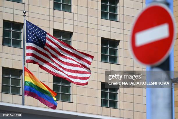 National and rainbow flags are pictured on the US embassy in Moscow on June 30, 2022. Moscow officials changed the official address of the US embassy...