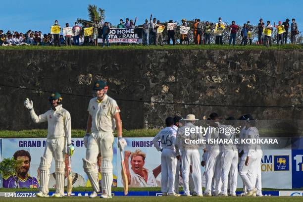 Protestors participate in an anti-government demonstration outside the Galle International Cricket Stadium during the second day play of the first...