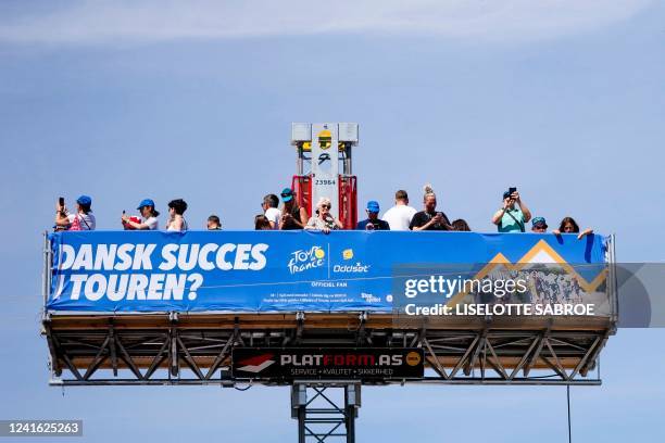 Visitors stand on a platform with a banner reading in Danish 'Danish success in the Tour ? as they enjoy a view over the Tour de France fan park at...