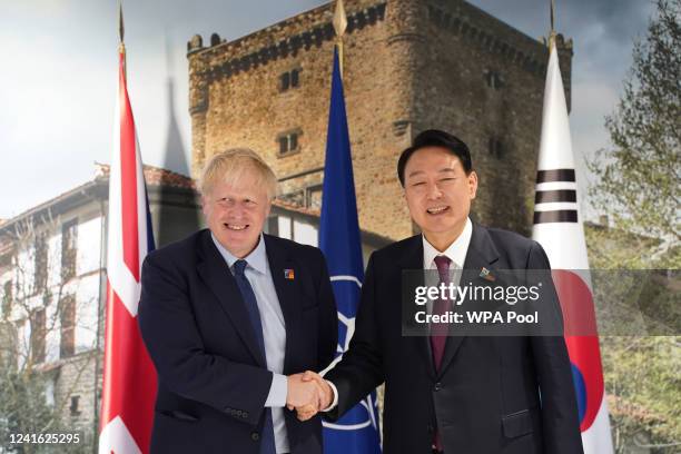 British Prime Minister Boris Johnson greets South Korea's President Yoon Suk-yeol ahead of a bilateral meeting during the NATO summit in Madrid, on...