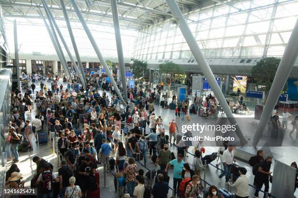 Passengers are seen waiting in a long line in front of Eurowing ticket service counter at Duesseldorf airport in Duesseldorf, Germany on June 30,...