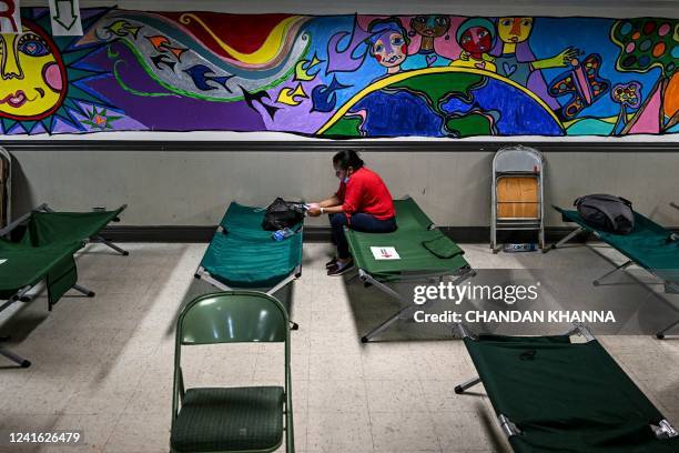 Migrant sits at a shelter in San Antonio, Texas on June 29, 2022. - Dozens of migrants wait in line outside a shelter in San Antonio, most of them...