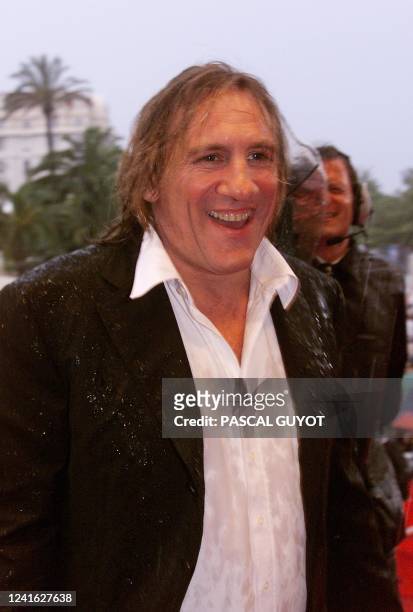 French star Gerard Depardieu arrives under heavy rain late 17 May at the Palais des Festivals for the screening of "La Vita e Bella" by Italian...
