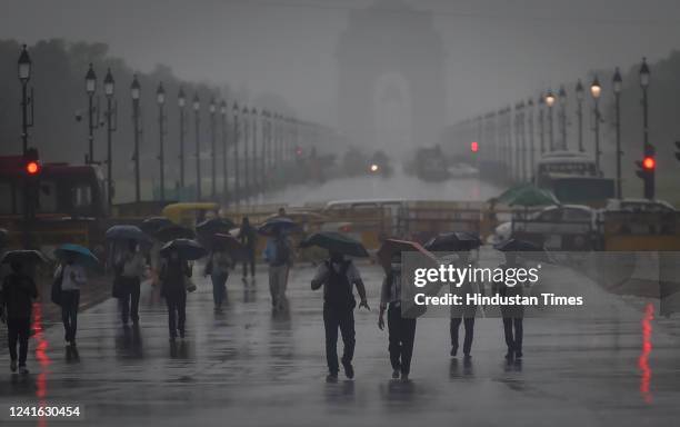 Commuters during heavy rain near India Gate at Rajpath on June 30, 2022 in New Delhi, India. Delhi on Thursday woke up to thundershowers, with heavy...