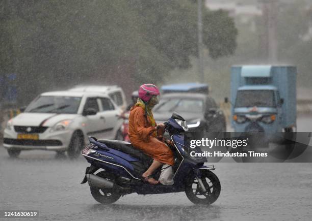 Commuters out in the rain at Sector 27 road on June 30, 2022 in Noida, India. Delhi on Thursday woke up to thundershowers, with heavy rainfall...