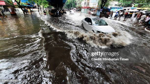 Vehicles wade through a waterlogged road due to heavy rains, near Vandana Cinema, in Thane, on June 30, 2022 in Mumbai, India.