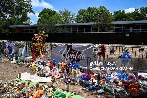 Mementos decorate a makeshift memorial to the victims of a shooting at Robb Elementary School in Uvalde, Texas, on June 30, 2022. - Nineteen young...