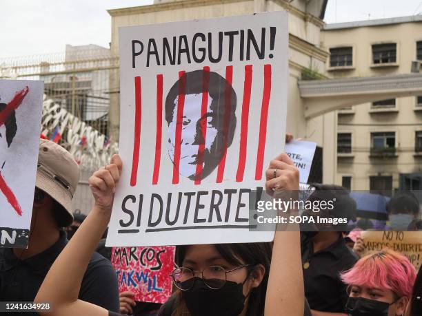 Protester holds a placard with a picture of the former Philippine President Rodrigo Duterte with red lines during the demonstration. Militant groups...
