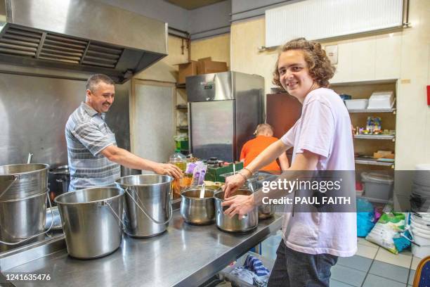 Ukrainian refugee Ruskin Khabibullin and his son Nikita Khabibullin , both followers of Hare Krishna, pose for aphotograph in the kitchen after...